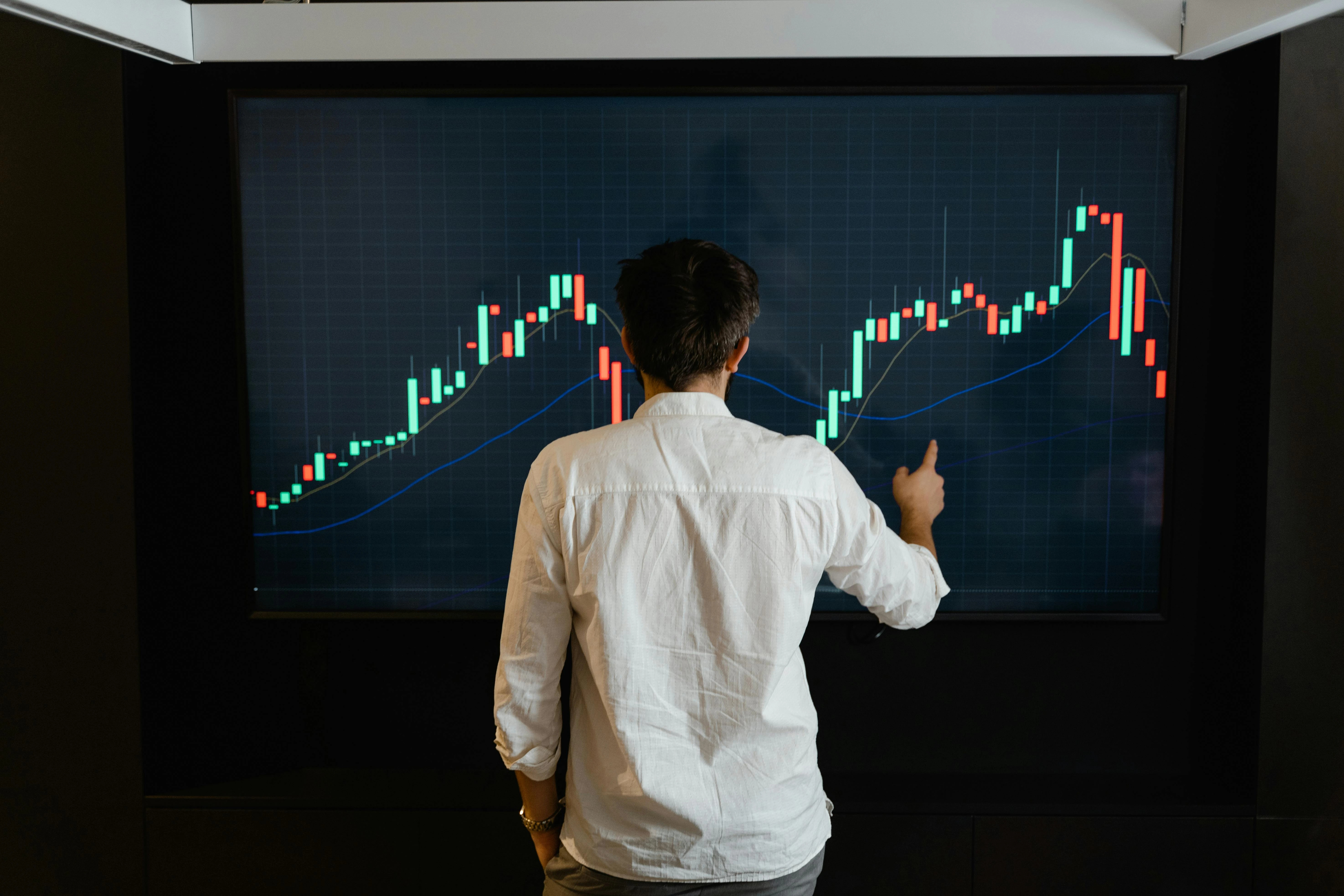 an image showing someone in front of a screen with trend line graph, indicating change over time